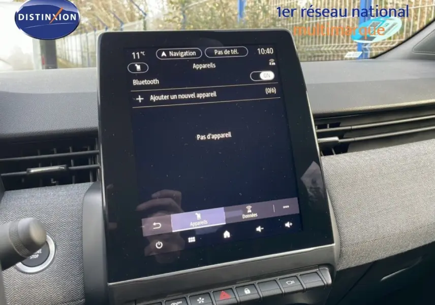 Vue rapprochée de l’écran tactile central de la Renault Clio rouge Désir Métal, affichant le menu Bluetooth.