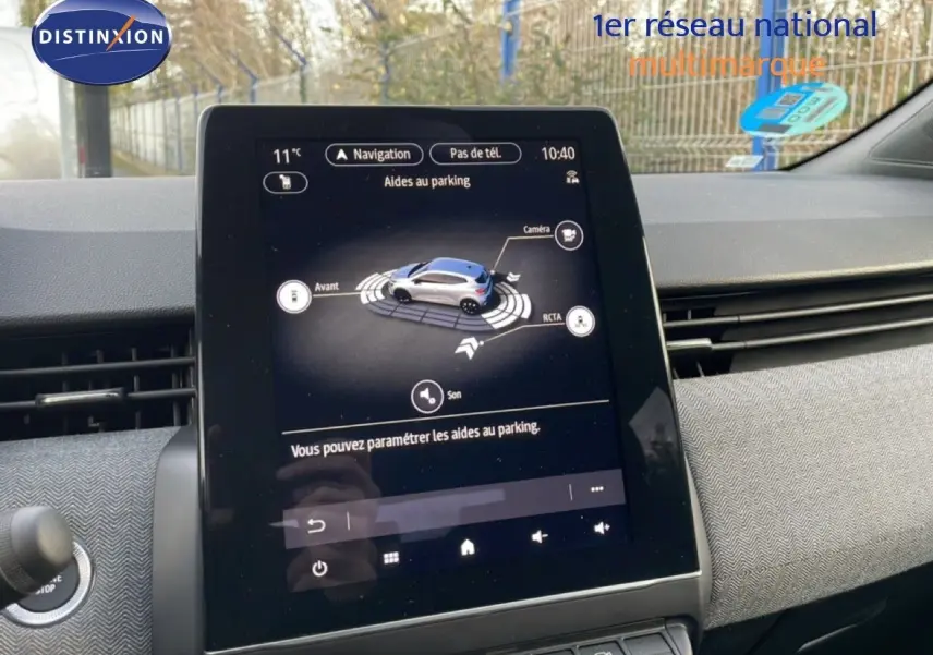 Écran tactile central de la Renault Clio 2025 affichant l'aide au parking dans un intérieur gris et noir.