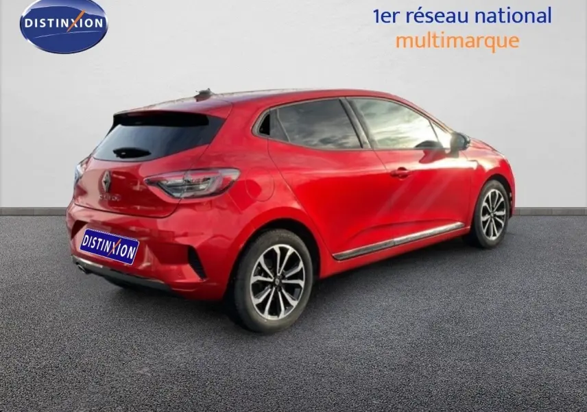 Renault Clio 2025 rouge désir métal vue 3/4 arrière droit, jantes alliage et vitres teintées visibles.