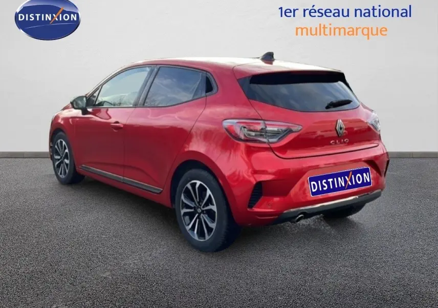 Vue 3/4 arrière droite d'une Renault Clio rouge désir métal 2025 avec jantes alliage et vitres teintées.