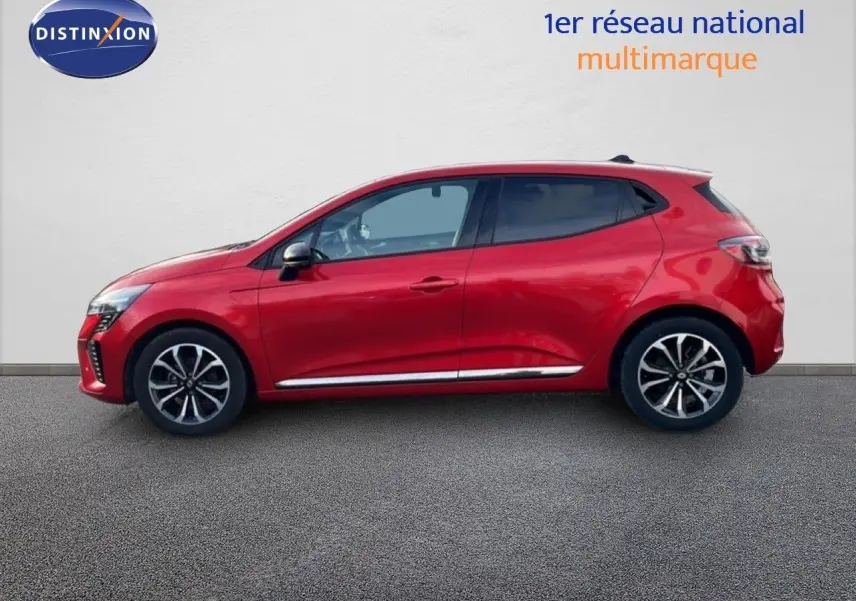 Profil droit d'une Renault Clio 2025 rouge désir métal avec jantes alliage et lignes chromées basses.