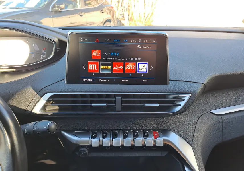 Vue intérieure du tableau de bord du Peugeot 5008 gris 2019, avec écran tactile central affichant les radios FM.