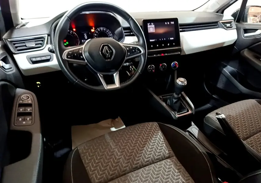 Vue intérieure avant de la Renault Clio Business 2023, tableau de bord blanc, volant cuir noir, écran tactile central.