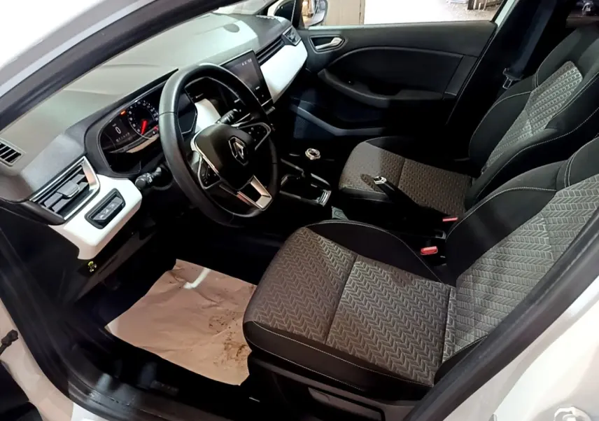 Vue intérieure côté conducteur de la Renault Clio Business TCe 100 GPL 2023 avec sièges tissu gris et tableau de bord noir et blanc.