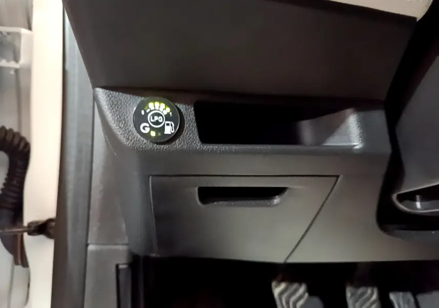 Gros plan sur le tableau de bord noir de la Renault Clio blanc, avec indicateur GPL allumé côté conducteur.