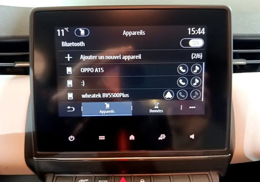 Écran tactile central de la Renault Clio Business blanc, affichant le menu Bluetooth avec plusieurs appareils connectés.