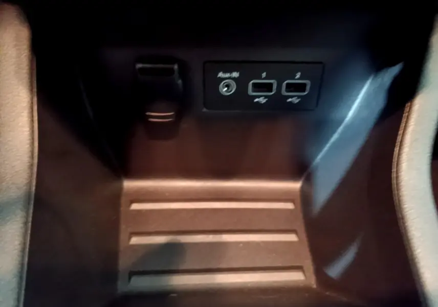 Vue rapprochée de la console centrale noire de la Renault Clio Business avec ports USB et prise auxiliaire visibles.