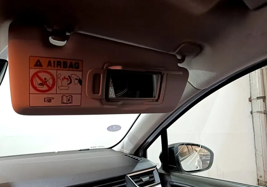 Vue intérieure côté passager de la Renault Clio Business blanche, avec pare-soleil et rétroviseur extérieur visible.