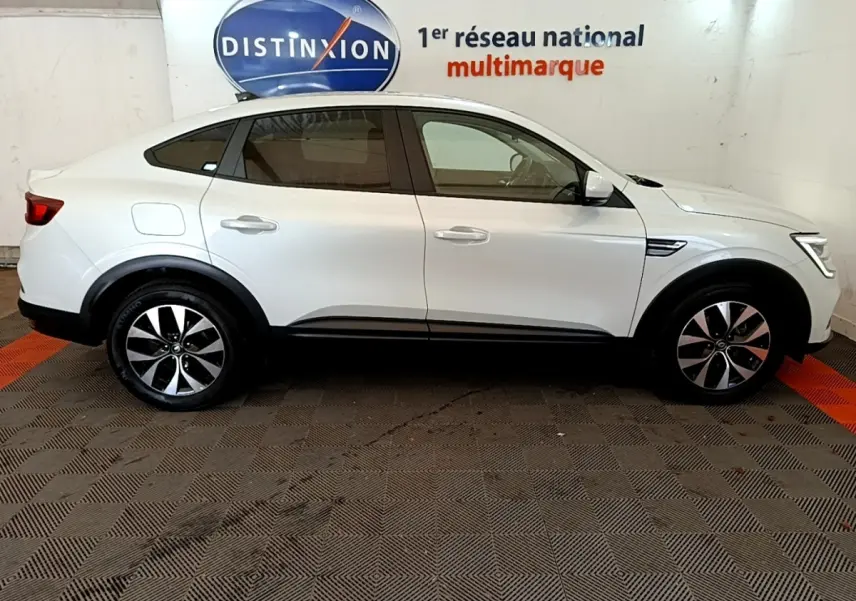 Profil droit d'un Renault Arkana blanc 2023 avec jantes alliage et poignées de porte couleur carrosserie.