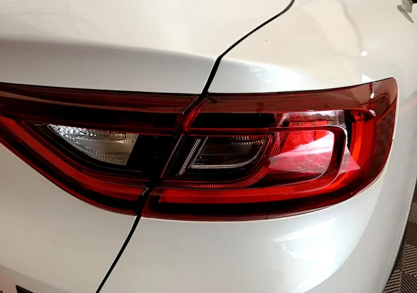 Gros plan sur le feu arrière droit rouge et blanc du Renault Arkana blanc Evolution E-Tech 2023.