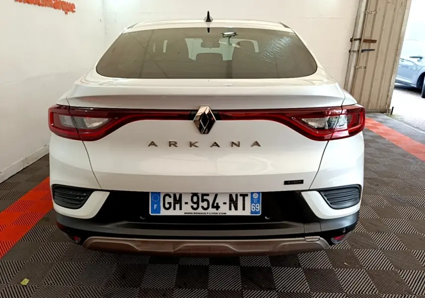 Vue arrière d'une Renault Arkana blanche 2023 avec feux LED reliés et logo centré sur le coffre.