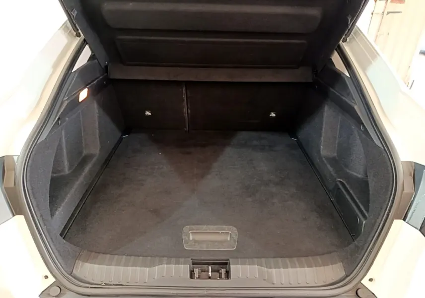 Coffre ouvert vu de l'arrière d'un Renault Arkana blanc, montrant un espace de chargement propre et spacieux.