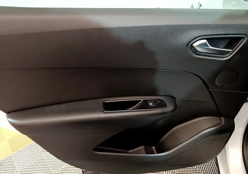 Gros plan sur la porte intérieure côté conducteur du Renault Arkana blanc, avec poignée et commande de vitre noire.