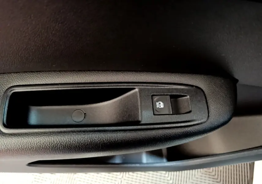 Gros plan sur la poignée intérieure de porte noire avec bouton de verrouillage, Renault Arkana blanc 2023.