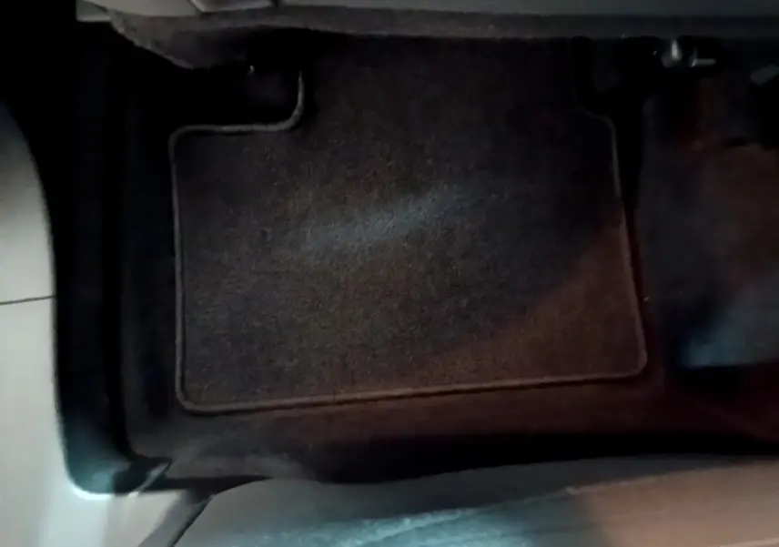 Tapis de sol noir côté conducteur du Renault Arkana blanc, vue rapprochée de l'intérieur au sol.