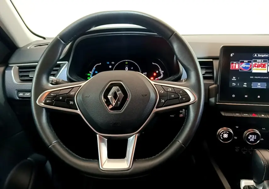 Vue frontale du volant noir en cuir du Renault Arkana 2023 avec tableau de bord numérique et écran tactile central.
