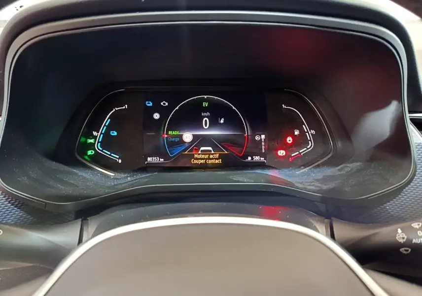 Vue rapprochée du combiné d'instruments numérique du Renault Arkana blanc, affichant les alertes et indicateurs hybrides.