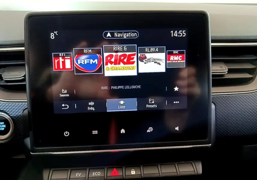 Écran tactile central du tableau de bord de la Renault Arkana blanc, affichant les radios en mode navigation.
