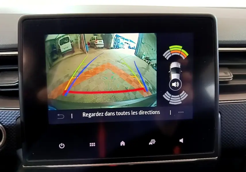 Écran tactile central montrant la caméra de recul avec guidage coloré sur Renault Arkana blanc, vue intérieure.