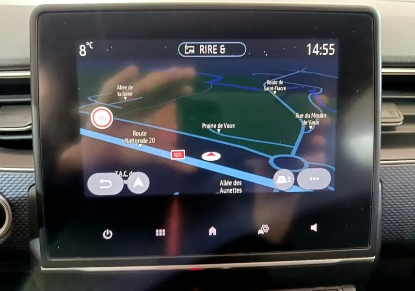 Écran tactile central du tableau de bord du Renault Arkana blanc, affichant la navigation 3D en plein jour.