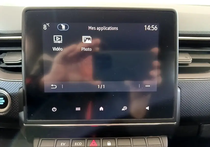 Écran tactile central du tableau de bord du Renault Arkana blanc, vue frontale rapprochée avec commandes en dessous.