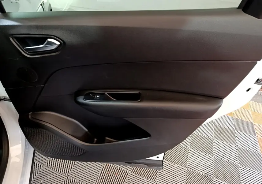 Vue intérieure de la porte arrière gauche noire du Renault Arkana blanc, avec poignée et commande de vitre intégrée.