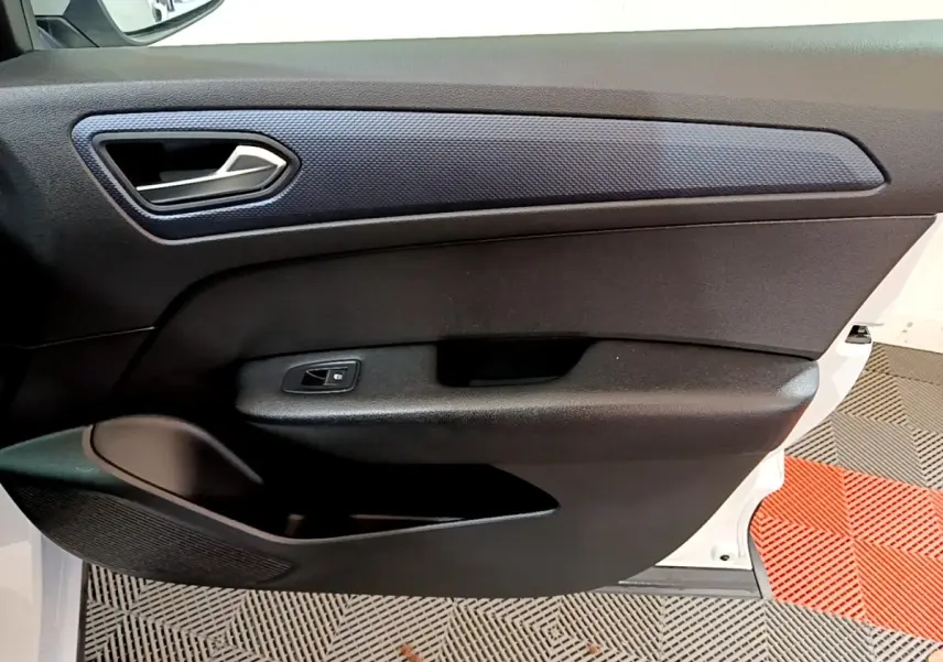 Vue intérieure côté gauche de la porte avant blanche du Renault Arkana avec poignée argentée et habillage noir texturé.