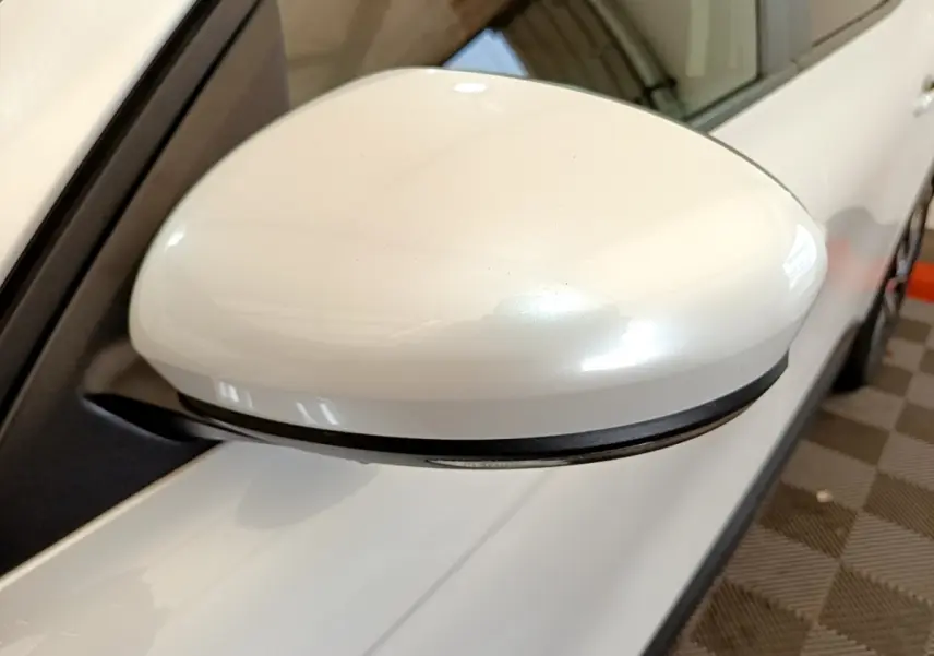 Rétroviseur droit blanc du Renault Arkana Evolution E-Tech 145, vue rapprochée côté extérieur avec carrosserie visible.