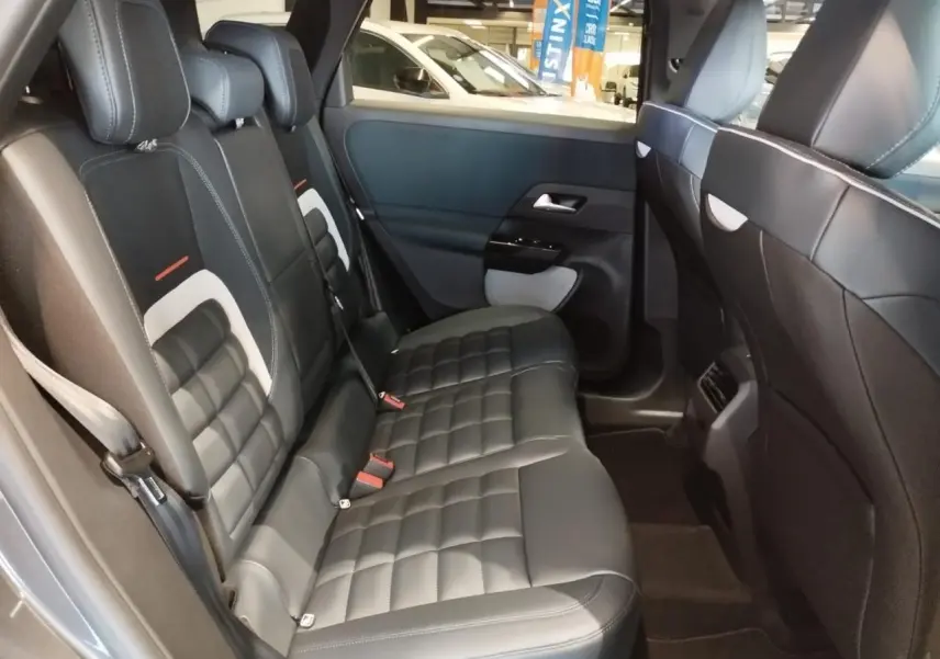 Vue latérale intérieure des sièges arrière en cuir noir avec surpiqûres blanches du Citroën C5 Aircross gris 2026.