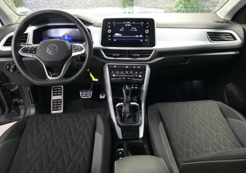 Vue intérieure frontale du tableau de bord et volant cuir multifonction du Volkswagen T-Roc gris édition Life Plus 2025.