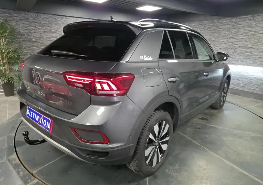 Vue 3/4 arrière droite du Volkswagen T-Roc gris métallisé avec attelage démontable et jantes alliage 17 pouces.