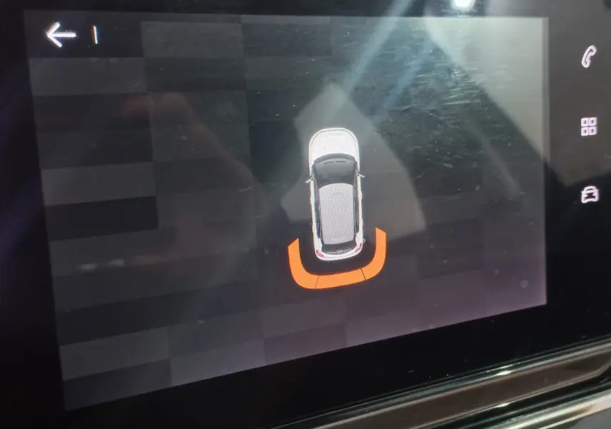 Affichage tactile intérieur montrant la silhouette blanche d'une Citroën C3 vue de dessus avec alerte de proximité arrière en orange.