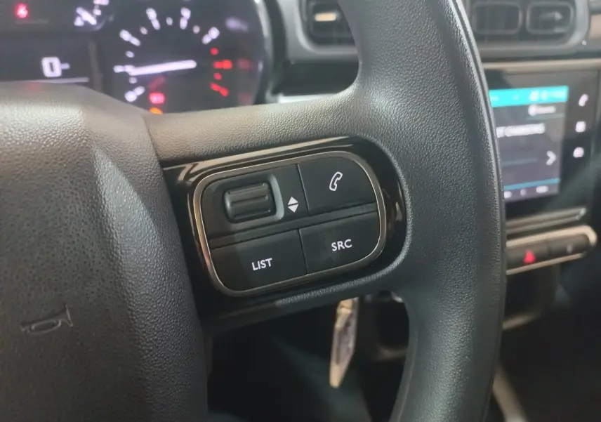 Gros plan sur le volant multifonctions noir de la Citroën C3 2024 avec commandes audio et téléphone intégrées.