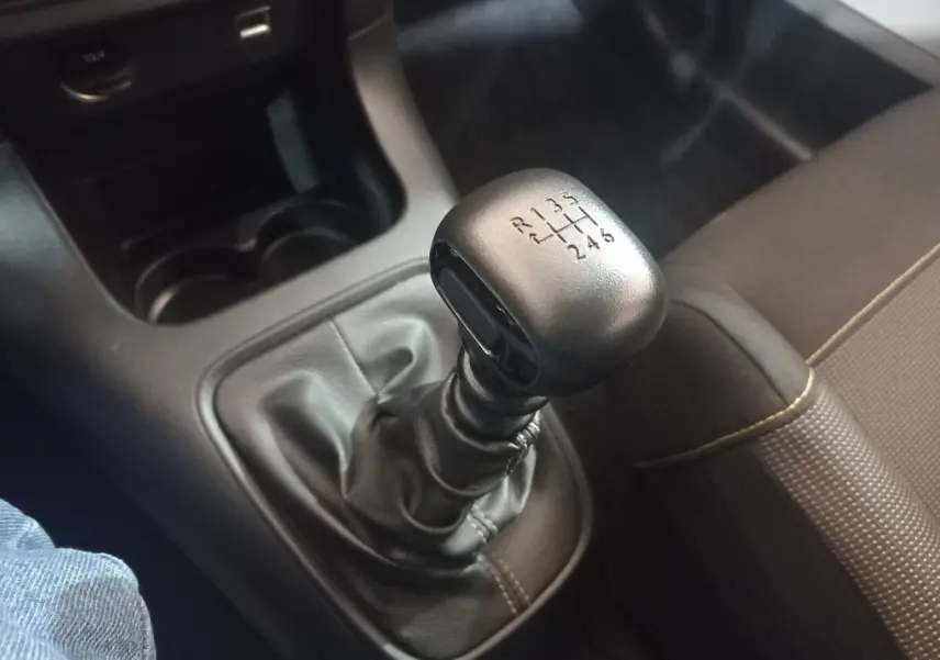 Gros plan sur le levier de vitesses manuel noir de la Citroën C3 2024, avec sellerie marron visible à droite.