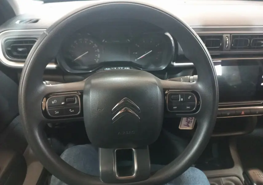 Vue rapprochée du volant multifonctions noir de la Citroën C3 2024 avec tableau de bord et écran tactile.