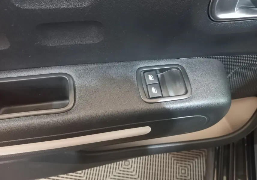 Détail de la porte côté conducteur de la Citroën C3 noire 2024, avec commandes des vitres électriques et poignée intégrée.