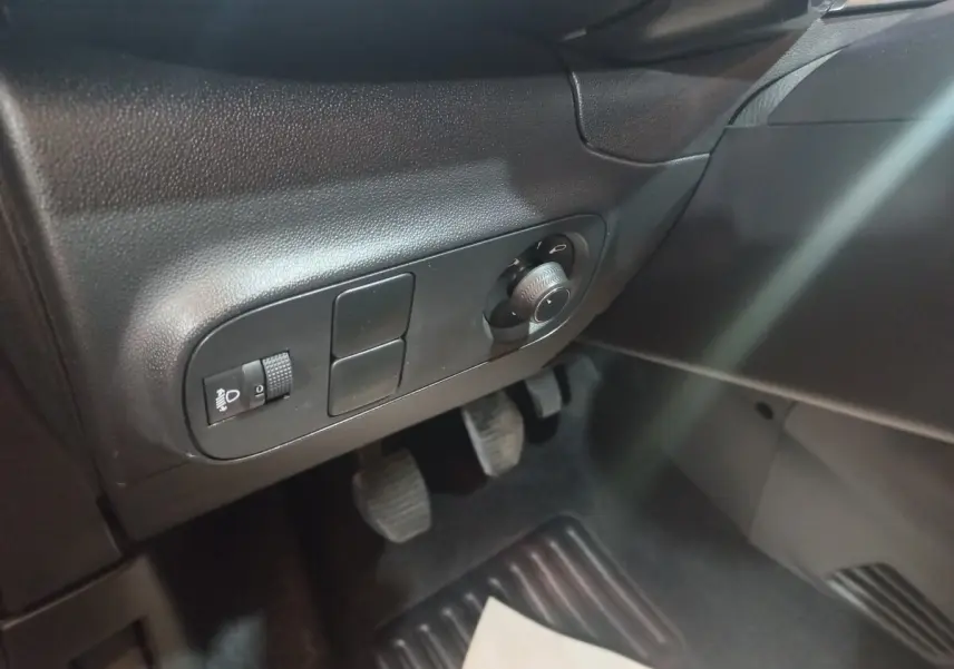Vue intérieure côté conducteur du Citroën C3 noir 2024, avec commandes d’éclairage et pédales visibles.