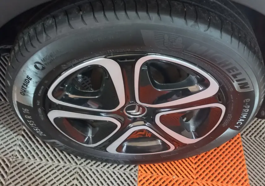 Gros plan sur la roue avant gauche noire de la Citroën C3 2024 avec jante alliage bicolore et pneu Michelin.