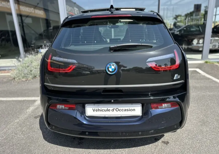 Vue arrière d'une BMW i3 électrique bleue de 2022 avec feux LED distinctifs et logo BMW visible.