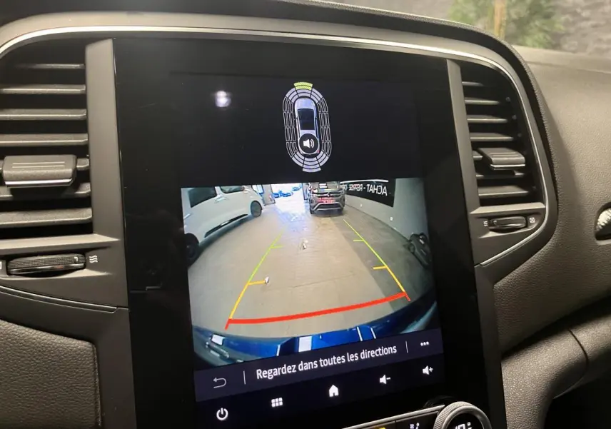 Écran central de la Renault Mégane hybride affichant la caméra de recul avec guidage de trajectoire coloré.