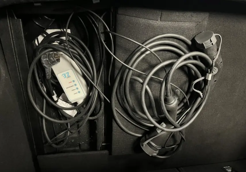 Coffre de Renault Mégane hybride 2021 avec câbles de recharge Flexicharger et Wallbox rangés.