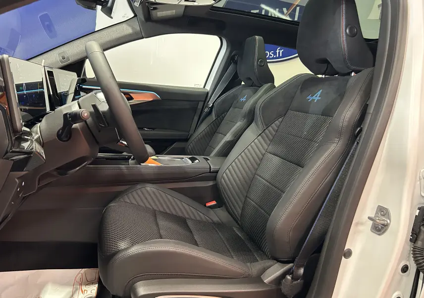 Vue intérieure côté gauche des sièges avant en cuir et alcantara noirs avec logo Alpine bleu sur Renault Austral blanc nacré.