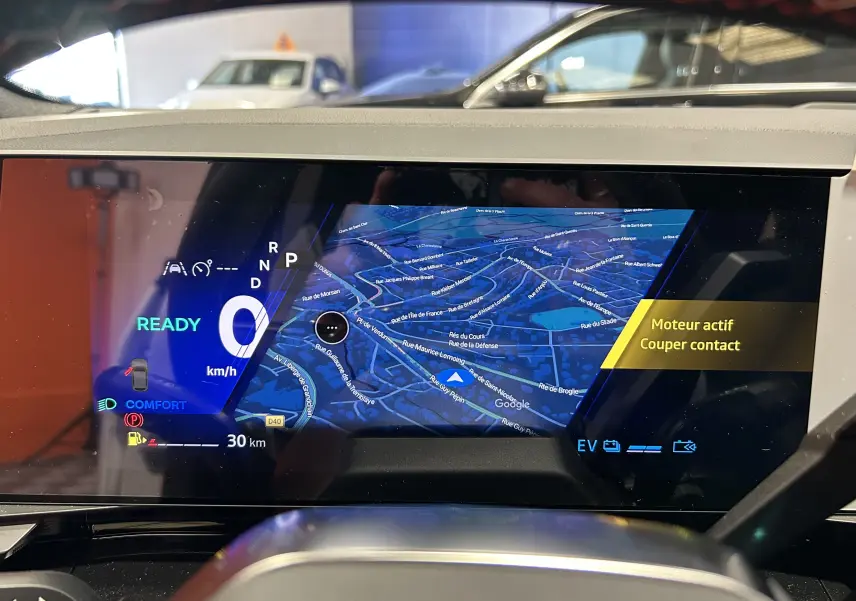 Affichage numérique du tableau de bord Renault Austral blanc nacré, avec navigation 3D et indication moteur actif.