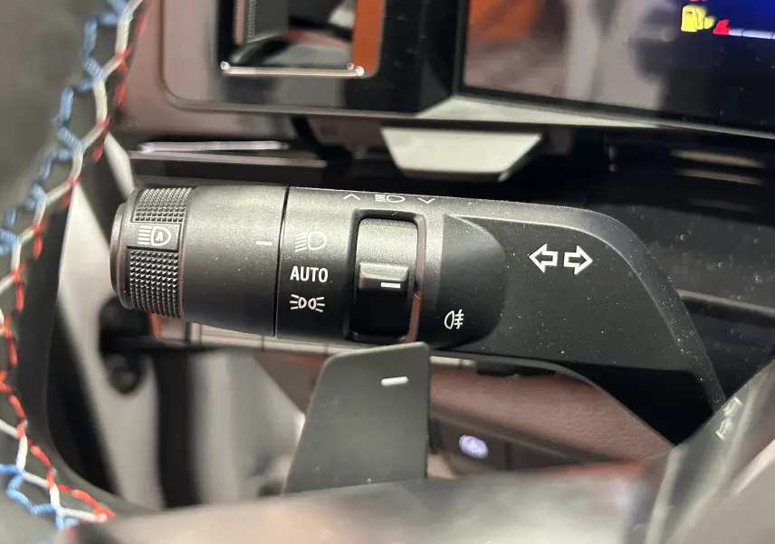 Gros plan sur la commande des feux et clignotants à gauche du volant du Renault Austral blanc nacré satin.