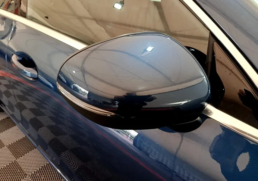 Rétroviseur côté gauche bleu foncé d'une Mercedes CLA 180 d Business Line, vue rapprochée sur la portière.