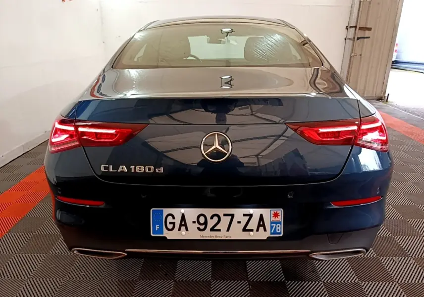 Vue arrière d'une Mercedes CLA 180 d noire avec feux LED allumés et double sortie d'échappement chromée.