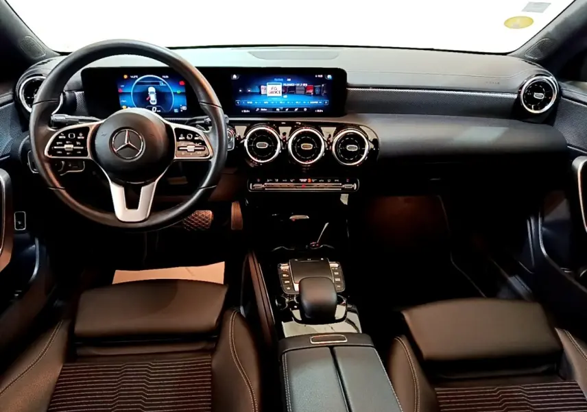 Vue intérieure avant de la Mercedes CLA 180 d Business Line 2021, tableau de bord noir avec écran tactile panoramique et volant multifonctions cuir alu.