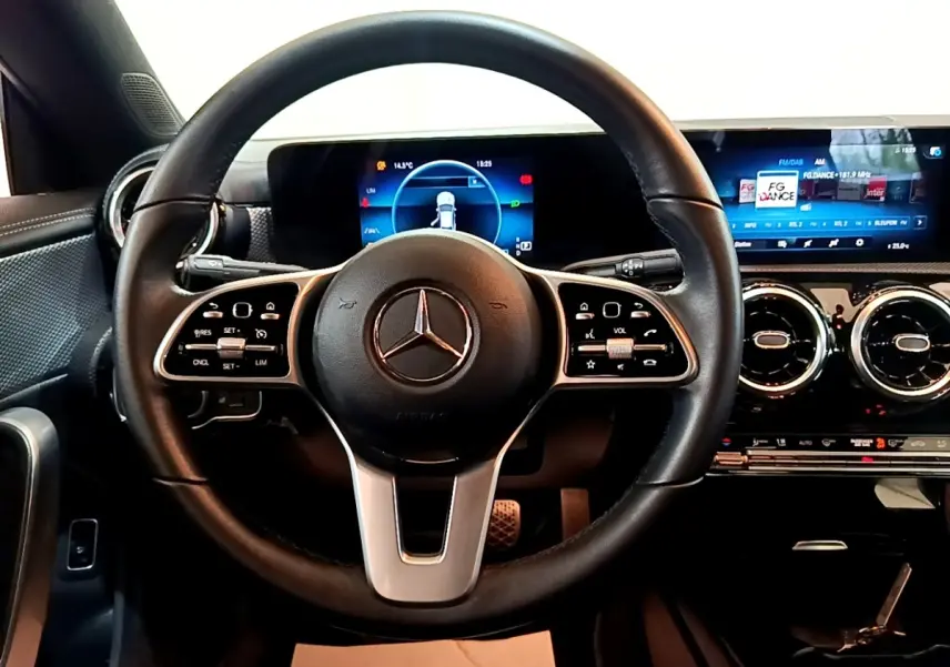 Vue intérieure centrée sur le volant cuir et alu d'une Mercedes CLA 180 d 2021 avec tableau de bord numérique lumineux.