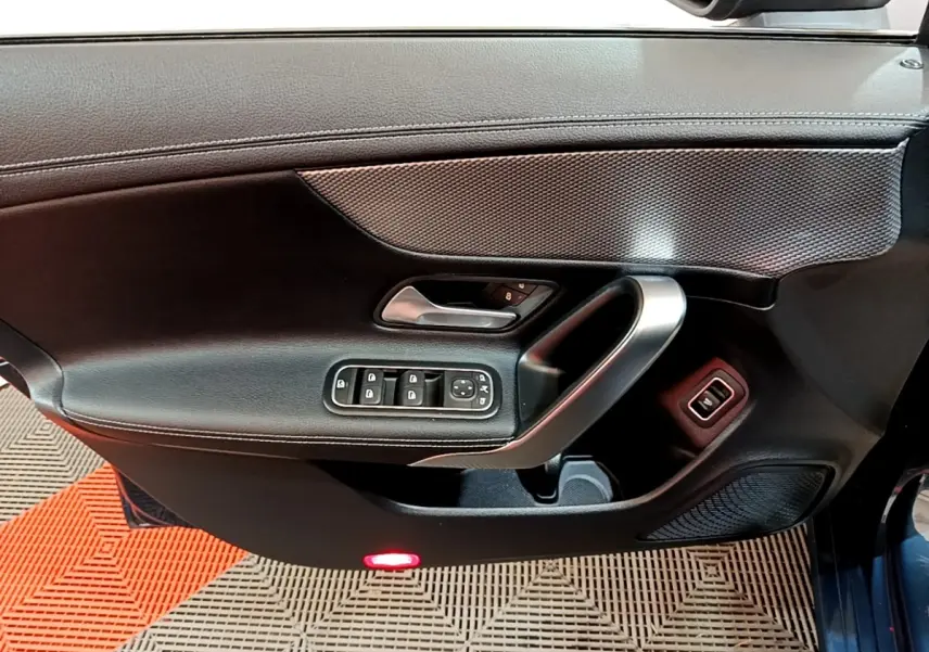 Vue intérieure côté gauche de la porte d’une Mercedes CLA 180 d Business Line 2021 avec commandes électriques et poignée alu.