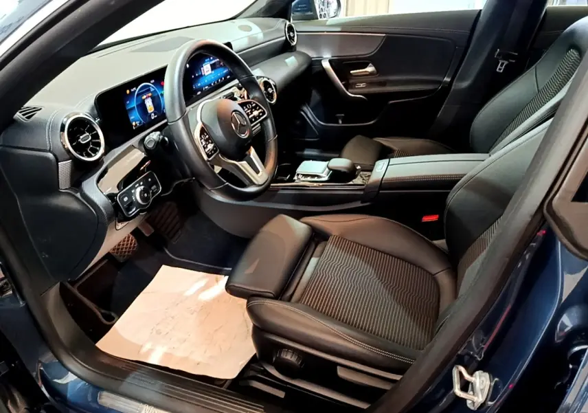Vue intérieure côté conducteur de la Mercedes CLA 180 d Business Line avec tableau de bord numérique et volant cuir alu multifonctions.